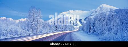 Fahrzeug leichte Wanderwege auf Schnee Alyeska Highway, Alaska, USA Stockfoto