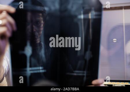 Der Arzt schaut bei der Patientin x-ray. Die Arbeit der Klinik Arzt Stockfoto