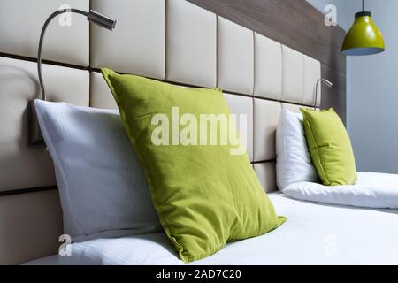 Grüne Kissen, Leselampen und Leder bett Kopfteil im modernen Schlafzimmer Stockfoto