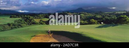 Gewitterwolken über einsame Golfspieler spielen in Princeville Golf, Hawaii, USA Stockfoto