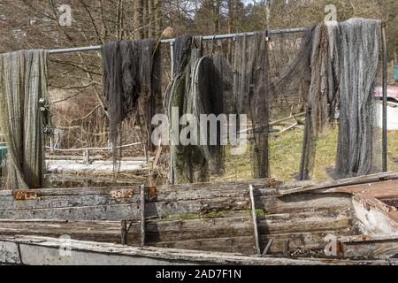 Fischernetze mit alten hölzernen Boot im Vordergrund. Stockfoto