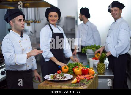 Team Köchinnen und Köche bei der Zubereitung der Gerichte Stockfoto