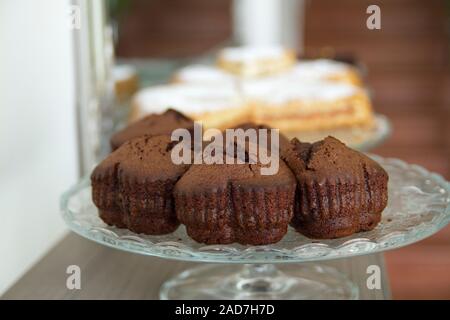 Schokolade in Herzform Muffins auf einem Glas Kuchen stehen mit unscharfen Apple Pies in den Hintergrund. Stockfoto