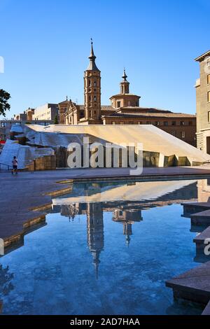 Der Brunnen zeigt Hispano - Amerika an der Plaza del Pilar in Zaragoza, die Kirche des Heiligen Johannes vom Panetes mit seinem schiefen Turm dahinter steckt Stockfoto