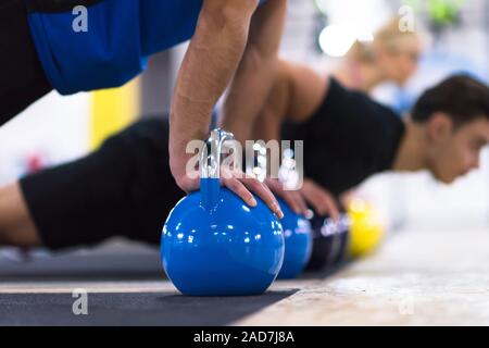 Die jungen Athleten, Liegestütze mit den Kettlebells Stockfoto