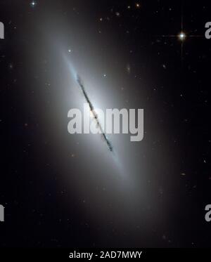 Dies ist ein einzigartiges NASA-Hubble-Weltraumteleskop Blick auf die Galaxie NGC 5866 gekippt fast Kante zu unserer Sichtlinie. Scharfe Hubbles Vision offenbart eine scharfe Staubband Division der Galaxie in zwei Hälften. Das Bild zeigt die Struktur der Galaxie: Eine subtile, rötlich Ausbuchtung, die einen hellen Kern, eine blaue Scheibe der Sterne, die parallel zu den Staub weg läuft, und eine transparente äußere Halo. Einige schwache, wispy Spuren von Staub kann gesehen werden weg von der Scheibe der Galaxie, die sich in der Ausbuchtung und inneren Halo der Galaxie. Der äußere Halo ist übersät mit zahlreichen gravitativ gebundenen Clus Stockfoto