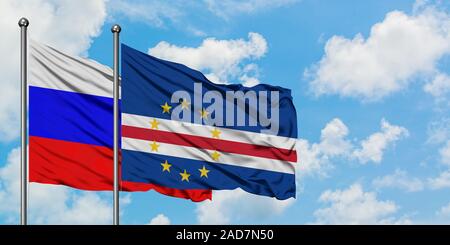 Russland und Kap Verde Flagge im Wind gegen Weiße bewölkt blauer Himmel zusammen. Diplomatie Konzept, internationale Beziehungen. Stockfoto