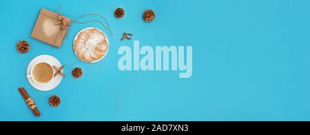 Trendy Weihnachten Hintergrund von Kaffee, Ingwer cookies, Handwerk Geschenkbox und goldenen Kegel auf cyan blau Hintergrund. Ferienzeit Konzept. Web Banner. Flach Stockfoto