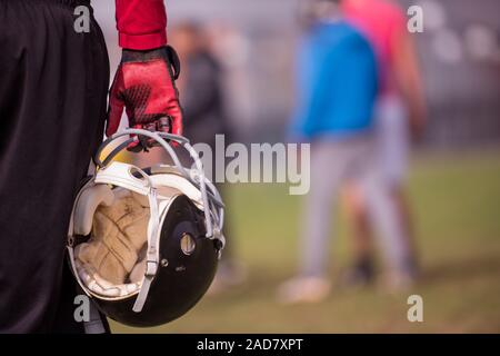 US-amerikanischer American-Football-Spieler halten Helm Stockfoto