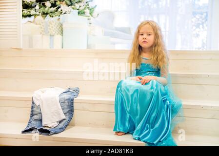 Nettes Mädchen sitzt in der Nähe von Weihnachten Baum Stockfoto