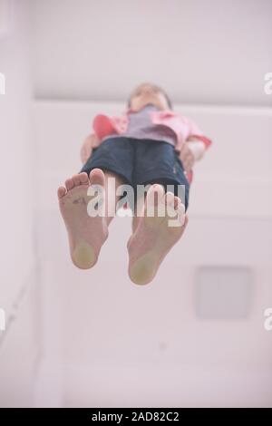 Kleiner Junge stehend auf transparentem Glas Boden Stockfoto