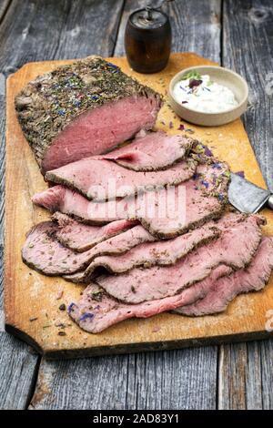 Traditionelles Mittagessen Fleisch mit in Scheiben geschnittenen Wurst Roastbeef und Remoulade als Closeup auf einem Schneidebrett Stockfoto