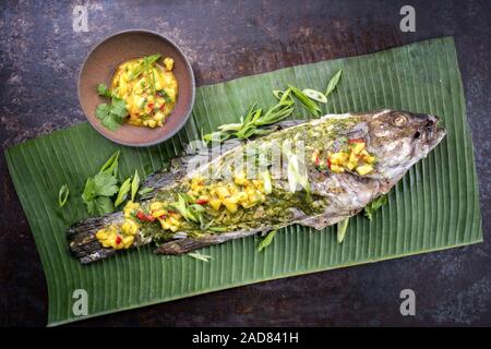 Grill Weißen Zackenbarsch mit chimichurri Sauce aji Criollo und Mango Chutney, Ansicht von oben in einem grünen Banana leaf Stockfoto