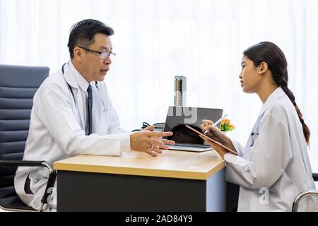 Zwei Ärzte im Krankenhaus die Diagnos des Patienten besprechen Stockfoto