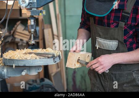 Die Zimmerleute mit elektrischen Bohrmaschine bohren Holzbrett Stockfoto