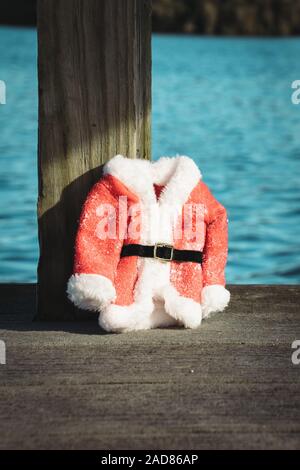 Weihnachten in Florida Konzept. Santa Anzug im Morgenlicht auf einem See Dock in Orlando, Florida. Vorbei schwimmen. Stockfoto