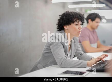 Weibliche Software Entwickler, die mit Desktop Computer Stockfoto