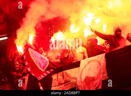 Fußball-Hooligans mit Maske halten Fackeln in Brand Stockfoto