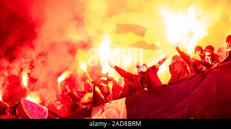 Fußball-Hooligans mit Maske halten Fackeln in Brand Stockfoto