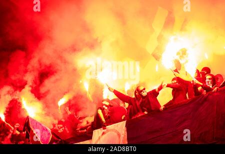 Fußball-Hooligans mit Maske halten Fackeln in Brand Stockfoto