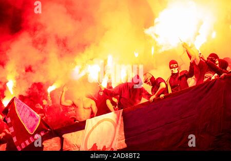 Fußball-Hooligans mit Maske halten Fackeln in Brand Stockfoto