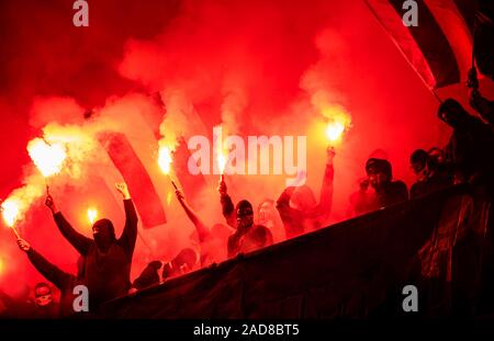 Fußball-Hooligans mit Maske halten Fackeln in Brand Stockfoto
