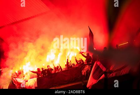 Fußball-Hooligans mit Maske halten Fackeln in Brand Stockfoto