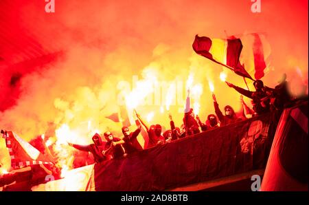 Fußball-Hooligans mit Maske halten Fackeln in Brand Stockfoto