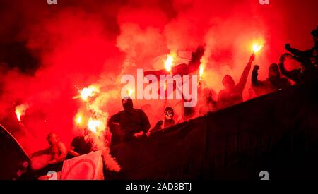 Fußball-Hooligans mit Maske halten Fackeln in Brand Stockfoto