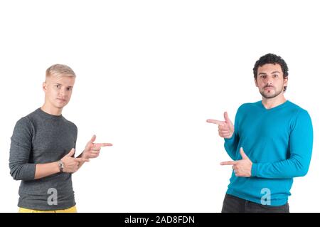 Zwei schöne Jungs irgendwo mit Fingern zeigen, isoliert auf weißem Stockfoto
