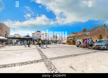 Touristen wandern auf dem Platz vor der Kirche Panagia, wie Sie das Dorf Oia auf Santorini, Griechenland ein. Stockfoto
