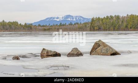 Katahdin hinter einem gefrorenen Teich mit gezackten Felsen im Vordergrund. Stockfoto