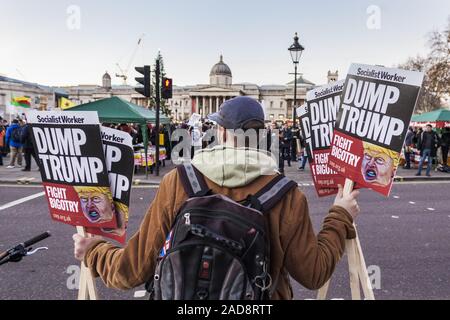 London, Greater London, UK. 3. Dezember, 2019. Eine Demonstrantin hält viele Fahnen anti-Trumpf in einer Demonstration gegen den 70. Jahrestag der NATO-Gipfel in London gefeiert. Credit: Celestino Arce Lavin/ZUMA Draht/Alamy leben Nachrichten Stockfoto