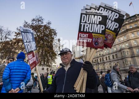 London, Greater London, UK. 3. Dezember, 2019. Eine Demonstrantin hält viele Anti-Trumpf-Banner eine Demonstration gegen den 70. Jahrestag der NATO-Gipfel in London gefeiert. Credit: Celestino Arce Lavin/ZUMA Draht/Alamy leben Nachrichten Stockfoto