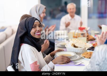 Schwarz moderne muslimische Frau iftar Abendessen mit der Familie genießen. Stockfoto