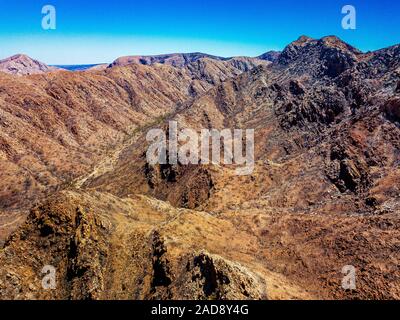 Luftaufnahme von Standley Chasm und den umliegenden West MacDonnell Ranges im abgelegenen Northern Territory nach einem Buschfeuer vor kurzem. Stockfoto