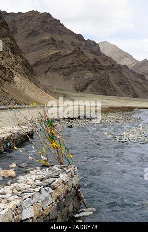 In der Yarlung Zangbo Fluss verankert, Darchog Gebetsfahnen markieren Sie die Basis der schroffen Berge in Brahmaputra Valley in der Autonomen Region Tibet der Volksrepublik China. Stockfoto