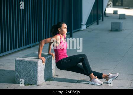 Frau in sportliche Kleidung, Reverse dips Foto Stockfoto