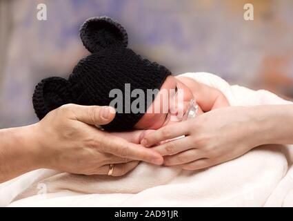 Neugeborenes Baby Boy Schlafen auf Eltern Hände Stockfoto