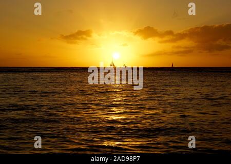 Sonnenuntergang über Segelboote und auf den Pazifischen Ozean auf dem Wasser vor der Küste von Oahu, Hawaii widerspiegelt. Stockfoto