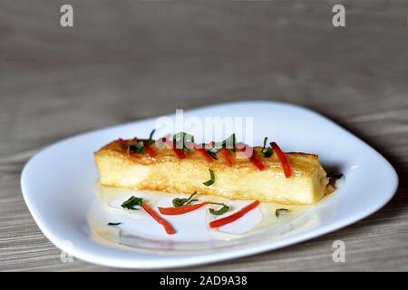 Gebackener Käse serviert mit Honig und Pfeffer Stockfoto