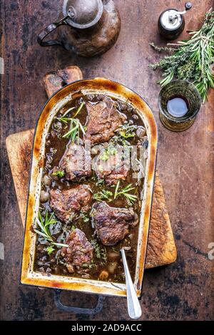 Traditionelle deutsche geschmorte Kalbsbäckchen in Braune Sauce mit Pilzen und Zwiebeln als Draufsicht in einem stewpot Stockfoto