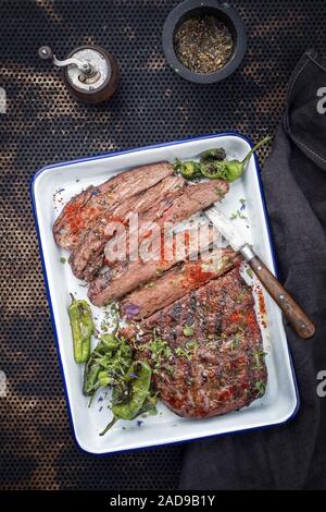 Traditionelle amerikanische Barbecue trockenen Jahren Flank Steak in Scheiben geschnitten als Draufsicht in einer Pfanne Stockfoto