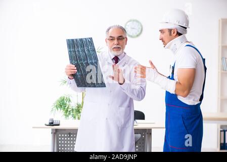 Junge männliche Auftragnehmer alte Arzt Stockfoto