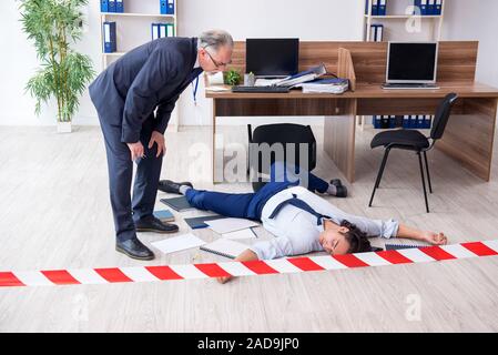 Forensische Ermittler und tote Mitarbeiter im Büro Stockfoto