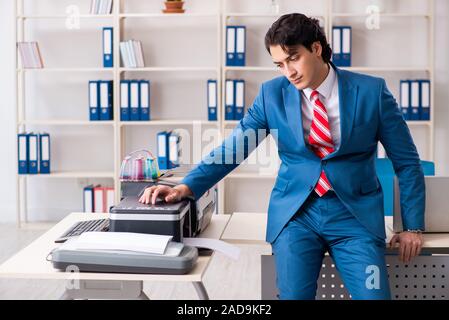 Junge Mitarbeiter von Kopien beim Kopieren von Maschine Stockfoto