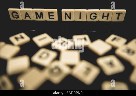 Datum Nacht in Brief Fliesen auf schwarzem Hintergrund geschrieben mit Brettspiele im Hintergrund Stockfoto