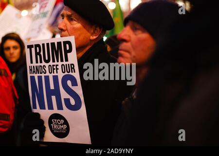 London, Großbritannien. 03 Dez, 2019. Ein Aktivist hält ein Plakat gegen jede Post-Brexit uns den Zugang zum Markt der britische National Health Service (NHS) während der Demonstration. Präsident Trump kam in Großbritannien auf einem dreitägigen Besuch in der vergangenen Nacht, vor allem der NATO-Gipfel in Watford zu besuchen. Aktivisten protestieren gegen die Trumpf Besuch auf dem Trafalgar Square. Credit: SOPA Images Limited/Alamy leben Nachrichten Stockfoto