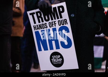 London, Großbritannien. 03 Dez, 2019. Ein Aktivist hält ein Plakat gegen jede Post-Brexit uns den Zugang zum Markt der britische National Health Service (NHS) während der Demonstration. Präsident Trump kam in Großbritannien auf einem dreitägigen Besuch in der vergangenen Nacht, vor allem der NATO-Gipfel in Watford zu besuchen. Aktivisten protestieren gegen die Trumpf Besuch auf dem Trafalgar Square. Credit: SOPA Images Limited/Alamy leben Nachrichten Stockfoto