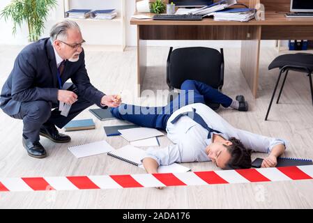 Forensische Ermittler und tote Mitarbeiter im Büro Stockfoto